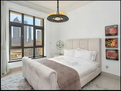 a white bedroom with a large bed and a large window at Skyline Souk 1 & 2 Bedroom Apartments I Burj Khalifa Views I Private Terrace I Gym, Pool, Parking & Wi-Fi in Dubai