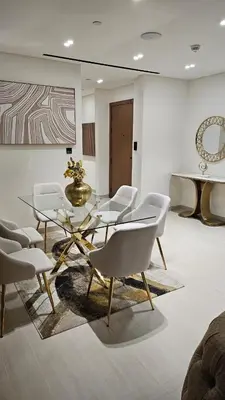 a dining room with white chairs and a glass table at LAREDA BY VIBY Vacation Homes Rental in Dubai