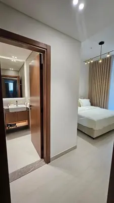 a bedroom with a bed and a bathroom with a sink at LAREDA BY VIBY Vacation Homes Rental in Dubai