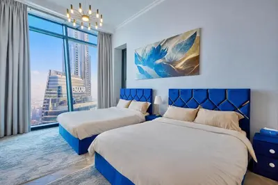 a bedroom with two beds and a large window at Luxurious Apartment in Downtown near Burj Khalifa in Dubai