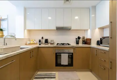 a kitchen with white cabinets and a stove top oven at Luxurious Apartment in Downtown near Burj Khalifa in Dubai