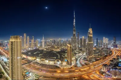 a view of a large city at night at Luxurious Apartment with Burj Khalifa View in Downtown in Dubai