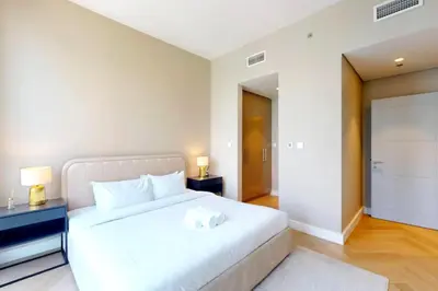 a bedroom with a large white bed and two lamps at Luxurious Apartment with Burj Khalifa View in Downtown in Dubai