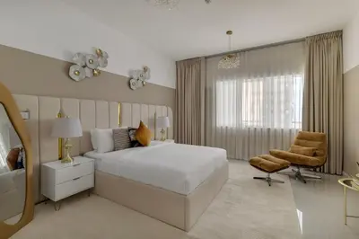 a bedroom with a bed and a chair and a mirror at Luxe 2 Bedroom Apartment in Dubai Marina in Dubai