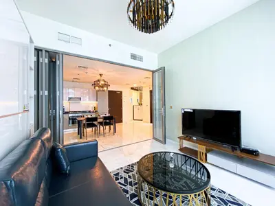 a living room with a leather couch and a television at Elegant 1BDR Sleeps 4 in Bayz-22 in Dubai