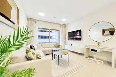 a living room with a couch and a table and a mirror at Cozy 1BR Apartment at Elite Residence Dubai Marina in Dubai