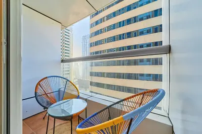 a balcony with two chairs and a glass table at Cozy 1BR Apartment at Elite Residence Dubai Marina in Dubai