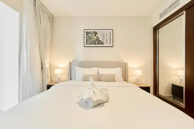 a bedroom with a large white bed with a bow on it at Cozy 1BR Apartment at Elite Residence Dubai Marina in Dubai