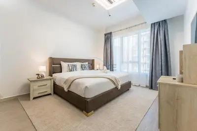 a bedroom with a bed and a large window at Compact 1BR, Just A Minute Drive to At the Top Burj Khalifa - Ontario Tower, Business Bay in Dubai