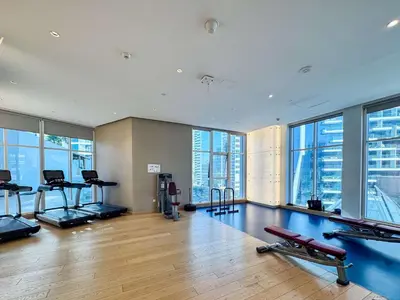 a gym with treadmills and exercise equipment in a building at PVH - Damac Maison Prive - Studio with Canal and Pool View in Dubai