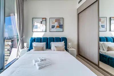 a bedroom with a large bed and a window at HAVN - High floor 1BR with Private Sky Pool, JVC in Dubai