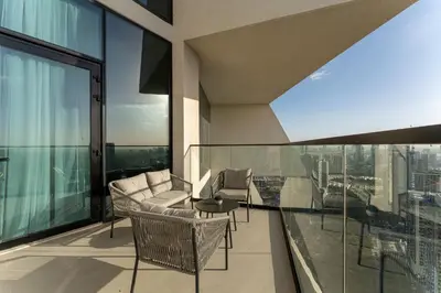 a balcony with chairs and a table on a building at HAVN - High floor 1BR with Private Sky Pool, JVC in Dubai