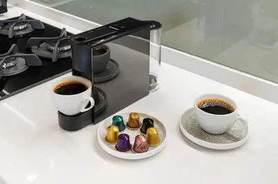 a counter with two cups of coffee and a plate of donuts at Stylish 1BR Apartment Peninsula One Business Bay in Dubai