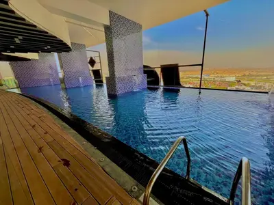 a swimming pool with blue water in a building at Chic Studio near Miracle Garden & GlobalVillage in Dubai