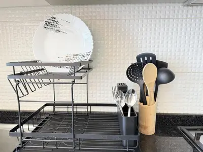 a dish rack with utensils on a kitchen counter at Chic Studio near Miracle Garden & GlobalVillage in Dubai