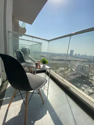 a room with a table and chairs on a balcony at Chic Studio near Miracle Garden & GlobalVillage in Dubai