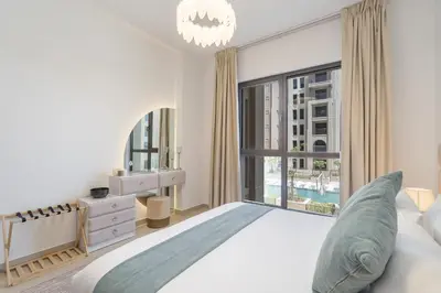a bedroom with a large bed and a large window at Vogue Madinat Jumeirah Living Jadeel near Burj AlArab, One-Bedroom Apartment with Large Balcony and Pool View, Access to All Amenities in Dubai