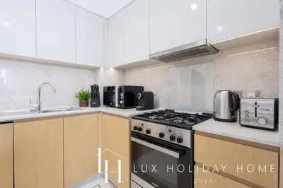 a kitchen with a stove top oven next to a sink at LUX 2BR High Floor - Near Dubai Mall in Dubai