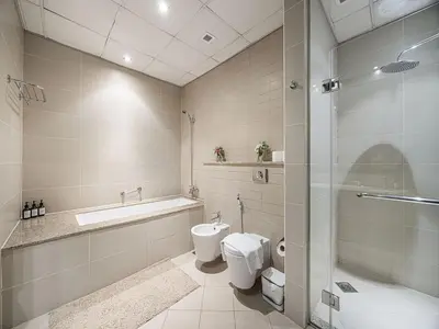 a bathroom with a toilet and a sink and a shower at Livin' Holidays - 2 BR - Anantara Beach View in Dubai