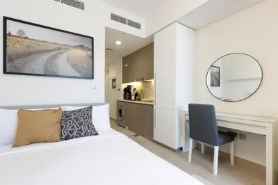 a bedroom with a bed and a desk and a mirror at Bright Studio with Balcony Close to Downtown Dubai in Dubai