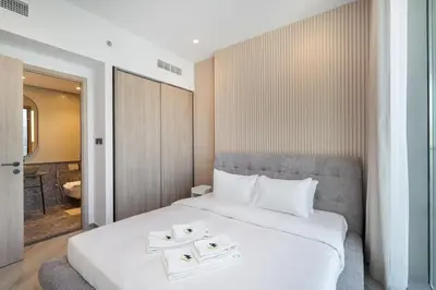 a bedroom with a large white bed with two trays on it at Mystic - Luxe 1BR Apt with Burj Khalifa & Canal Views in Dubai