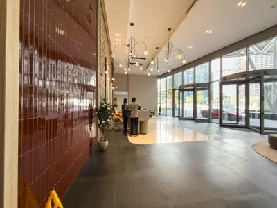 a lobby with people standing in a building at Mystic - Luxe 1BR Apt with Burj Khalifa & Canal Views in Dubai