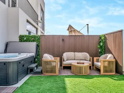 a patio with a hot tub and chairs and a table at Luxury 4BR Villa in Arabian Ranches 3, Resort-Style Living with Private Garden & Hot Tub in Nadd Shubayḩ