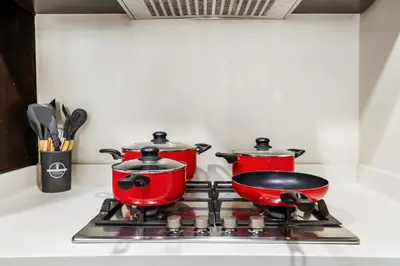 two pots and pans on a stove in a kitchen at Modern 1BR Apartment in DAMAC Merano Business Bay in Dubai