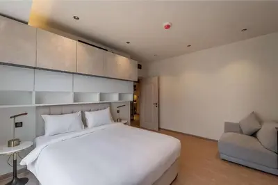 a bedroom with a large white bed and a couch at Murjan 2702 in Dubai