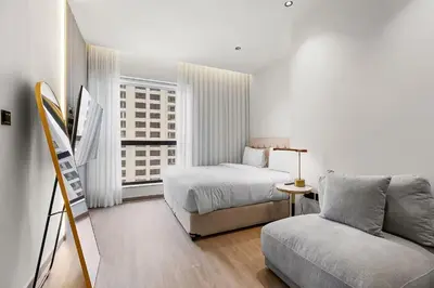 a white bedroom with a bed and a couch at Murjan 2702 in Dubai