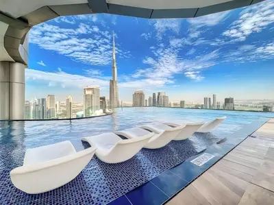 a infinity pool with white chairs on the edge of a city skyline at Luxury 1BR High floor Paramount Midtown in Dubai