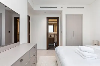 a white bedroom with a large bed and a mirror at Premium 3BR Study in Sobha Hartland in Dubai