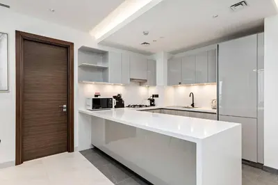 a kitchen with white cabinets and a white counter top at Premium 3BR Study in Sobha Hartland in Dubai