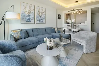 a living room with a blue couch and chairs at BurjKhalifaViews,1BHK, High Floor, Damac Paramount Tower B in Dubai