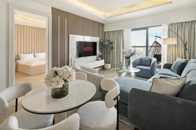 a living room with a couch and a table and chairs at BurjKhalifaViews,1BHK, High Floor, Damac Paramount Tower B in Dubai