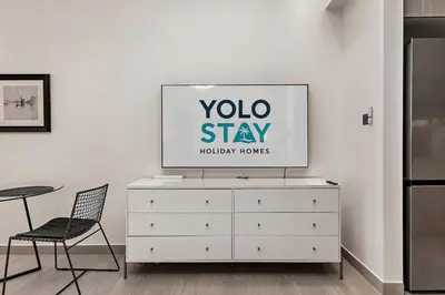 a tv on top of a dresser in a room at Chic Studio in Me Do Re JLT YOLO in Dubai