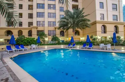 a swimming pool in front of a hotel at StayShort - Cozy Relaxing Studio in JBR - Walk to the Beach in Dubai