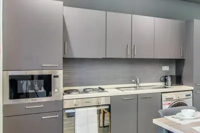a kitchen with white cabinets and a sink at StayShort - Cozy Relaxing Studio in JBR - Walk to the Beach in Dubai
