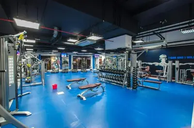 a gym with a blue floor and machines in it at StayShort - Cozy Relaxing Studio in JBR - Walk to the Beach in Dubai