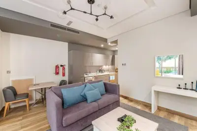 a living room with a purple couch and a kitchen at StayShort - Cozy Relaxing Studio in JBR - Walk to the Beach in Dubai