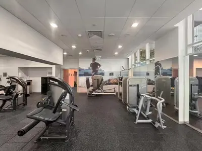 a gym with cardio equipment and a man in the background at Downtown Three Beds near to Burj Khalifa and Dubai Mall in Dubai