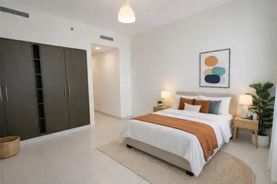 a white bedroom with a large bed and two lamps at Downtown Three Beds near to Burj Khalifa and Dubai Mall in Dubai