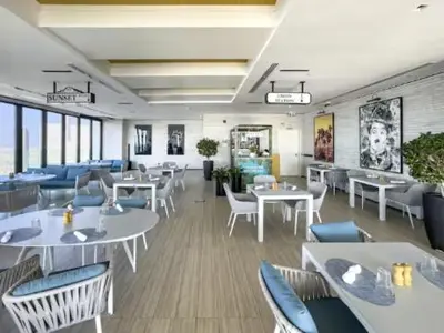 a restaurant with white tables and blue chairs at Restay Homes at Paramount Midtown Hotel - Infinity pool access included in Dubai