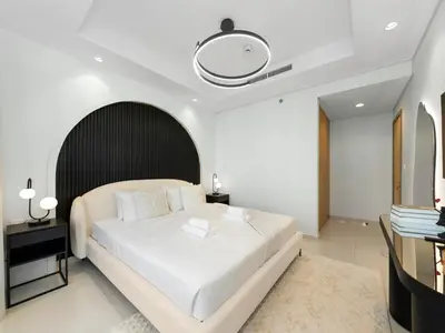 a bedroom with a large white bed and a mirror at Restay Homes at Paramount Midtown Hotel - Infinity pool access included in Dubai