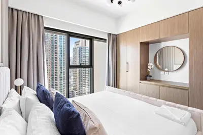 a bedroom with a large bed with a large window at Silkhaus Prime 1BDR in Burj Royale in Dubai