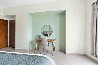 a bedroom with a dressing table and a mirror at Silkhaus 1 BDR in South Ridge on High Floor in Dubai