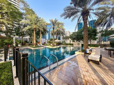 a swimming pool with palm trees in a city at Silkhaus 1 BDR in South Ridge on High Floor in Dubai