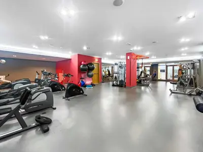 a gym with several treadmills and exercise bikes in it at Silkhaus 1 BDR in South Ridge on High Floor in Dubai