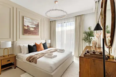 a bedroom with a large bed and a chandelier at Silkhaus Spacious 3BDR & Maid Tilal Al Ghaf in Dubai
