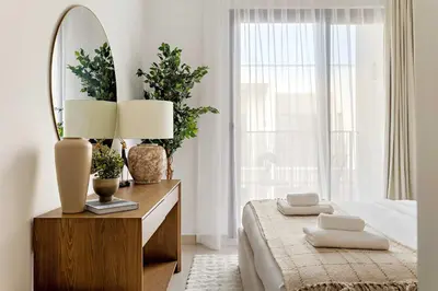a bedroom with a bed with a mirror and a dresser at Silkhaus Spacious 3BDR & Maid Tilal Al Ghaf in Dubai